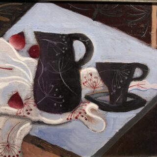 Jug and cup with saucer on a table top