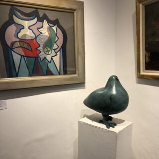 Painting on the wall with sculpture of a pigeon on a plinth