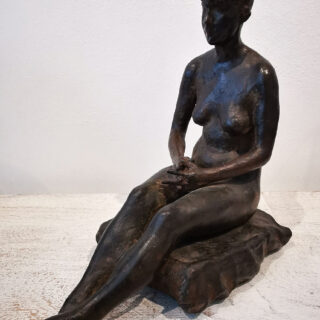 woman seated with hands clasped